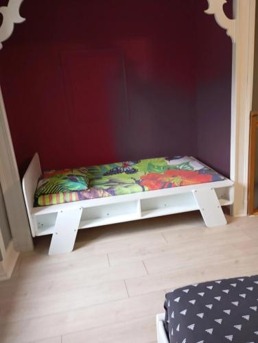 a small bed in a room with a wall at Appartement chaleureux à Nevy-sur-Seille 70 m² avec Wifi in Nevy-sur-Seille