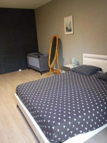 a bedroom with a large bed and a chair at Appartement chaleureux à Nevy-sur-Seille 70 m² avec Wifi in Nevy-sur-Seille