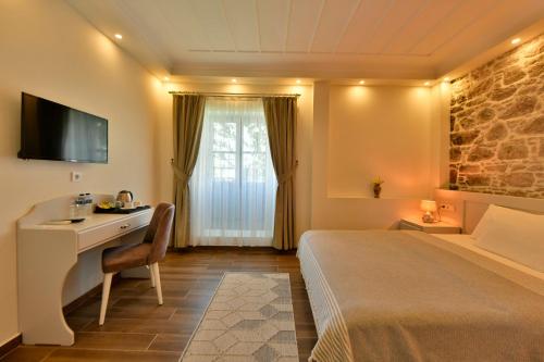 a hotel room with a bed and a desk at Cunda Ömer Ağa Konağı in Cunda