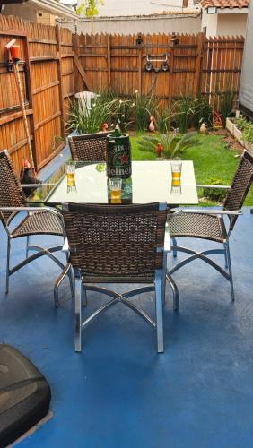 a patio table with three chairs and a drink on it at Casa Contêiner Luxo in Foz do Iguaçu