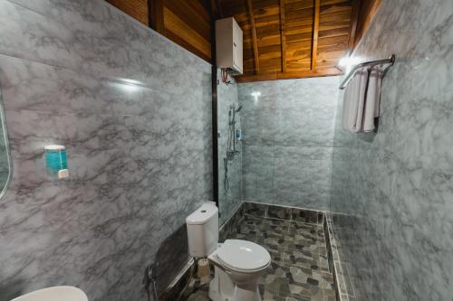 a bathroom with a toilet and a shower at The Polumb Garden Bedugul in Tabanan