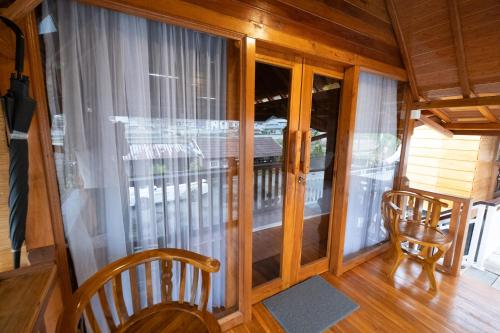 a room with a balcony with a chair and a window at The Polumb Garden Bedugul in Tabanan