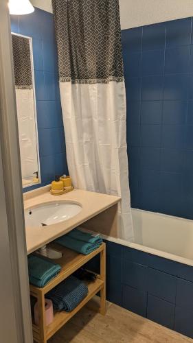 une salle de bain avec un lavabo, une baignoire et un miroir dans l'établissement Port de Hyères 4 personnes avec terrasse, à Hyères