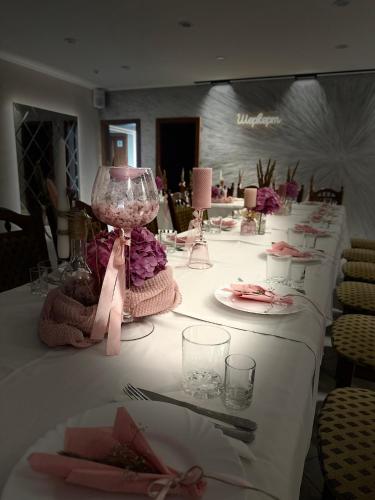 a table with a white table cloth with a pink lamp at Ресторан-Готель Шеркерт in Berehove