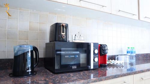 a microwave sitting on top of a kitchen counter at Elegant 2BR Golf View Oasis in Yas Island - Maids Room, Pool & Near Yas Mall in Yas Island