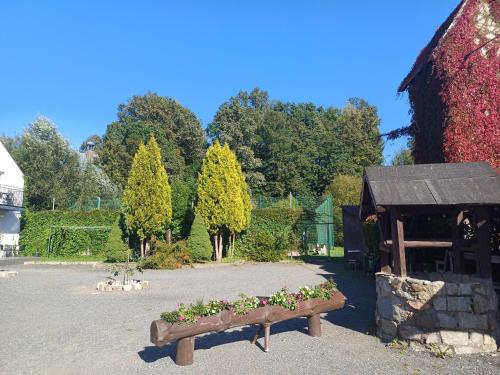 a bench with flowers in it next to a building at Gościniec Solan in Jeleniów