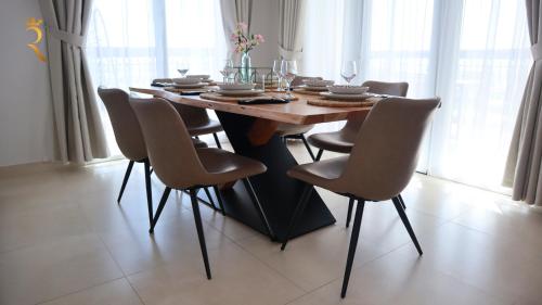 a dining room table and chairs in a room at Elegant 2BR Golf View Oasis in Yas Island - Maids Room, Pool & Near Yas Mall in Yas Island