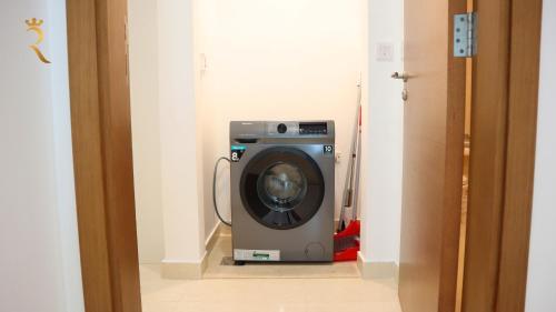 a washing machine sitting in a hallway in a room at Elegant 2BR Golf View Oasis in Yas Island - Maids Room, Pool & Near Yas Mall in Yas Island