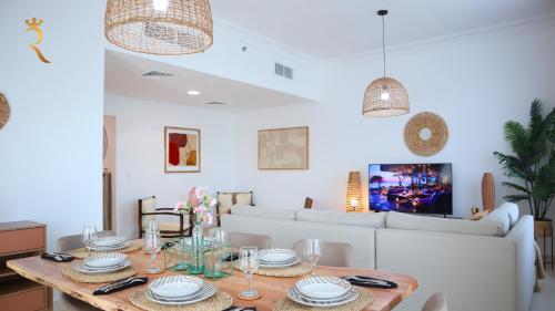 a dining room with a table and a couch at Elegant 2BR Golf View Oasis in Yas Island - Maids Room, Pool & Near Yas Mall in Yas Island