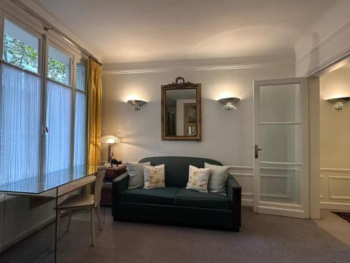 un salon avec un canapé, une table et un miroir dans l'établissement Luxury and cosy apartment in Paris, 16è Arrondissement, à Paris