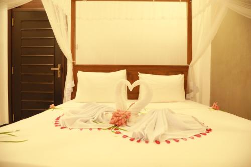 a white bed with a wedding dress and a heart at Gold Bubble in Ahangama