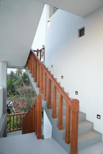 a staircase in a house with wooden railings at Gold Bubble in Ahangama