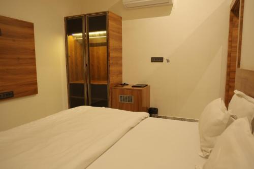 a hotel room with two beds and a closet at Hotel HS Inn Swiming Pool Room in Jaipur