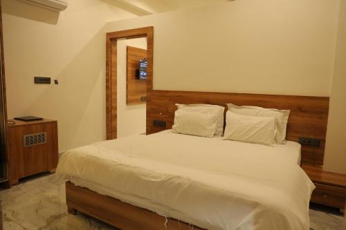 a bedroom with a bed with white sheets and pillows at Hotel HS Inn Swiming Pool Room in Jaipur