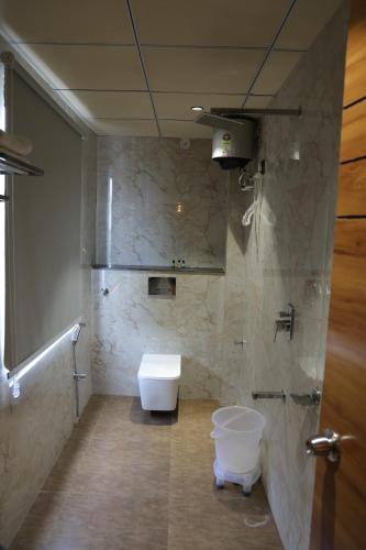 a bathroom with a toilet and a sink in it at Hotel HS Inn Swiming Pool Room in Jaipur