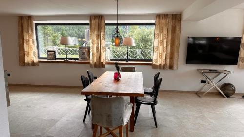a dining room with a table and chairs and a television at Lou Garden Suite in Auland