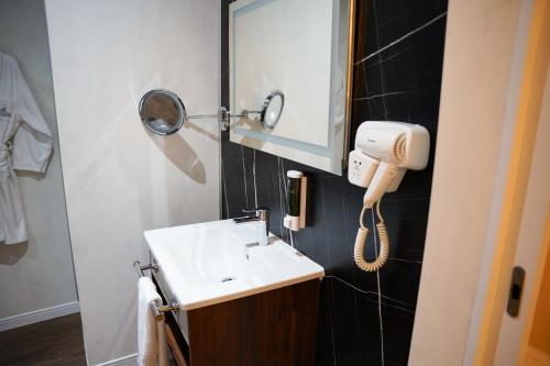 a bathroom with a sink and a mirror and a phone at Atlantis Alger in Alger