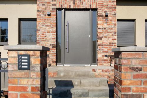 a brick building with a black door on it at Ferienwohnungen Stolzenhagener 7 in Lunow