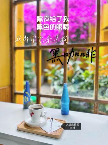 a cup of coffee sitting on a plate on a table at The Cloudland International Youth Hostel, Close to the city center,10 min walks to the subway, Close to the night market, old street, green lake, English-speaking service, free Activity convenient payment and visa cards are accepted in Kunming