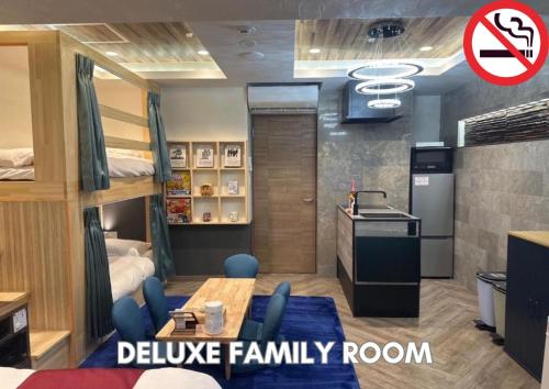 a room with bunk beds with a table and blue chairs at Hotel Pasela Living in Tokyo