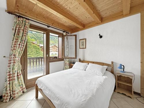 une chambre avec un lit et une grande fenêtre dans l'établissement SC316 - Duplex 8 Pers centre des Carroz, aux Carroz d'Arâches