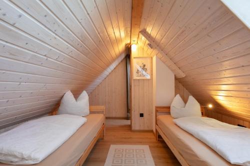 two beds in a room with a wooden ceiling at Ferienwohnungen Stolzenhagener 7 in Lunow