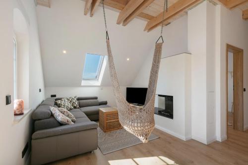 a living room with a couch and a hanging hammock at Ferienwohnungen Stolzenhagener 7 in Lunow