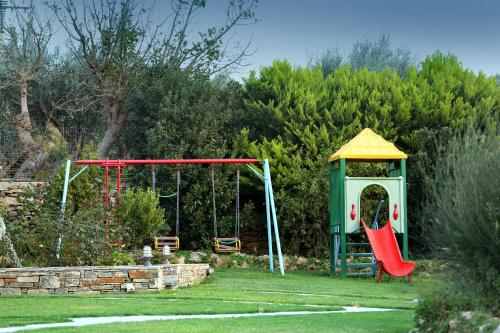 a playground with a swing and a gazebo at Politia Villas in Karistos