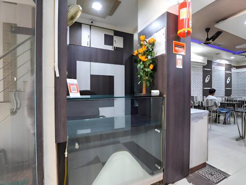 拉杰果德Hotel Atithi - Oposite Shreeji Hospital的大堂设有玻璃柜台和花瓶