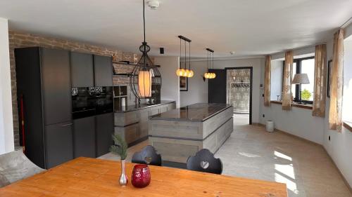 a kitchen with a wooden table and a counter at Lou Garden Suite in Auland