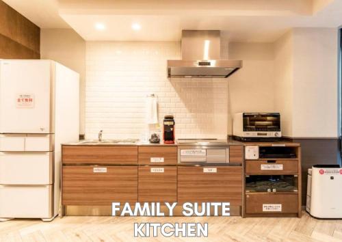 a kitchen with a white refrigerator and wooden cabinets at Hotel Pasela Living in Tokyo