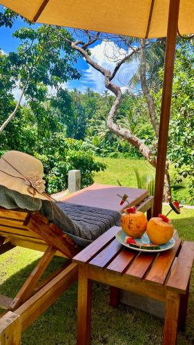 a wooden table with a plate of fruit on it at The Jungle Loft Galle in Galle