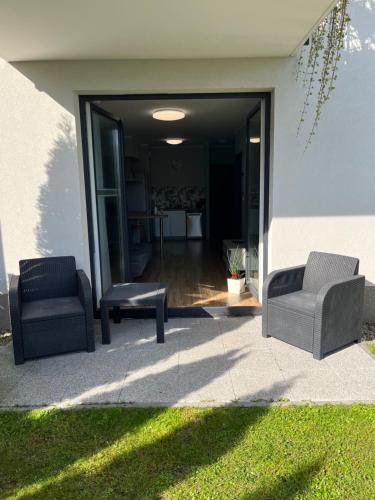 two chairs sitting on a patio in front of a house at 2 Tyskie Apartamenty z ogródkiem in Tychy