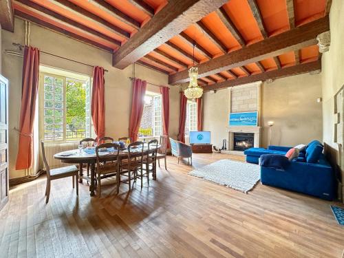 un salon avec une table et un canapé bleu dans l'établissement Keriner manoir 10 pieces avec parc arbore, à Pluguffan