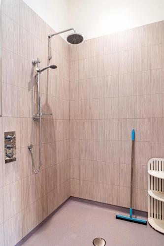 a shower in a bathroom with a tile wall at The Barn at Burfords with wood fired hot tub in Monksilver