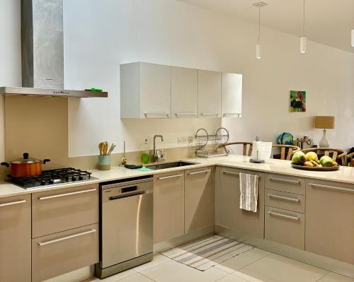 a kitchen with white cabinets and a sink at Luxury Apartment on the Beach in Belle Mare
