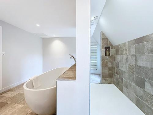 une salle de bain blanche avec une baignoire et une douche dans l'établissement Keriner manoir 10 pieces avec parc arbore, à Pluguffan