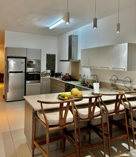 a kitchen with a table with a bowl of fruit on it at Luxury Apartment on the Beach in Belle Mare