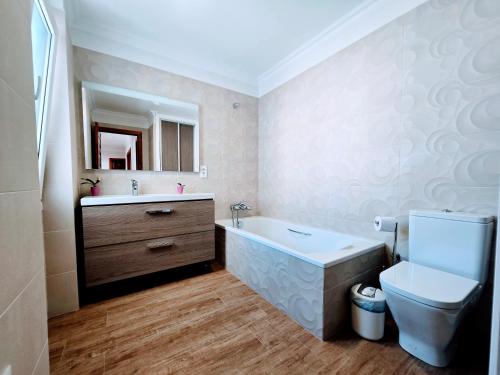 a bathroom with a tub and a toilet and a sink at VV Milenaiver "by henrypole home" in Los Cancajos