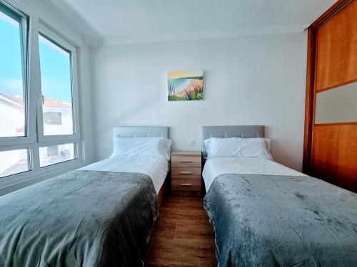 two beds sitting next to each other in a room at VV Milenaiver "by henrypole home" in Los Cancajos