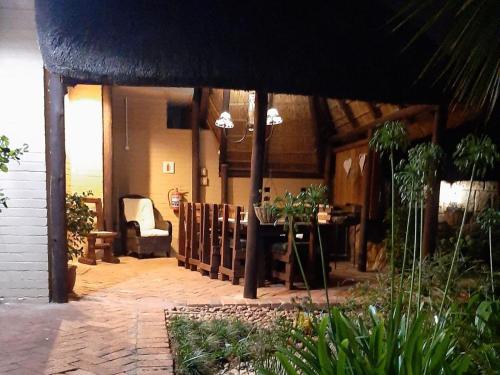 a patio with a table and a chair in a house at Wi Villa Lê Guest House in Fichardtpark