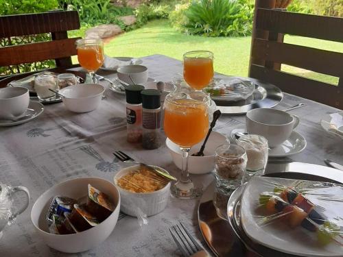 a table with plates of food and glasses of orange juice at Wi Villa Lê Guest House in Fichardtpark