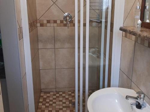 a bathroom with a shower and a toilet and a sink at Wi Villa Lê Guest House in Fichardtpark