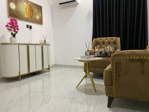 a living room with a chair and a table at Wenthruhomes in Ikota