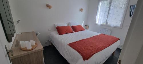 - une chambre avec un lit doté d'oreillers rouges dans l'établissement LE SILENCE DES BOIS Séjour romantique et bien-être, à Étoile-sur-Rhône