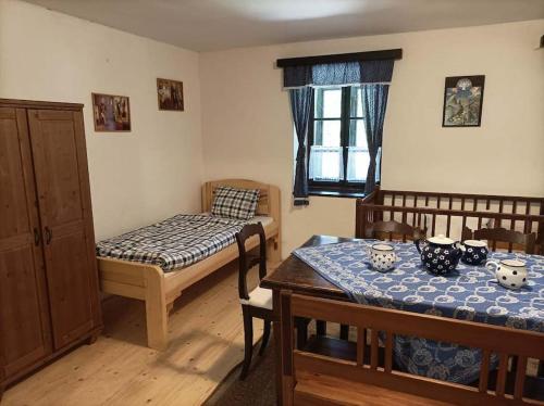 a room with two beds and a table and chairs at Chalupa pro 2 rodiny in Kněževes