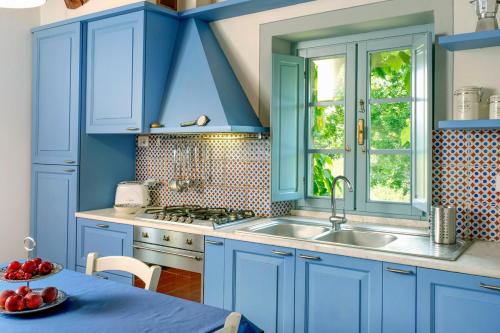 a blue kitchen with a sink and a table at Residenza Ca De Frati in Arezzo