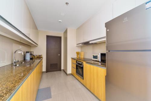 a large kitchen with a stainless steel refrigerator at Luxury Condo Ocean View 1,2,3, & 4 Bedrooms Infinity Pool Gym Spa Next to Okada Solaire MOA NAIA Airport in Manila