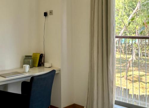 a desk with a laptop on it next to a window at Luxury Apartment on the Beach in Belle Mare