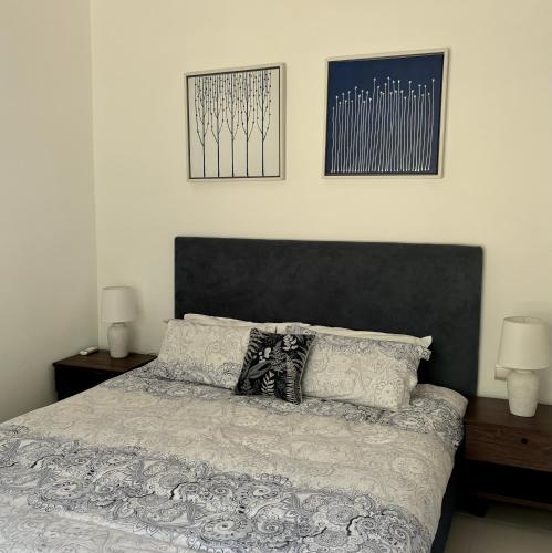 a bedroom with a bed with two lamps and two pictures at Luxury Apartment on the Beach in Belle Mare